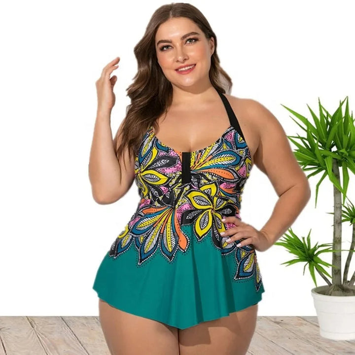 Frau im bunten Badeanzug mit Blumenmuster, Plus-Size, vor weißem Hintergrund mit Pflanze.