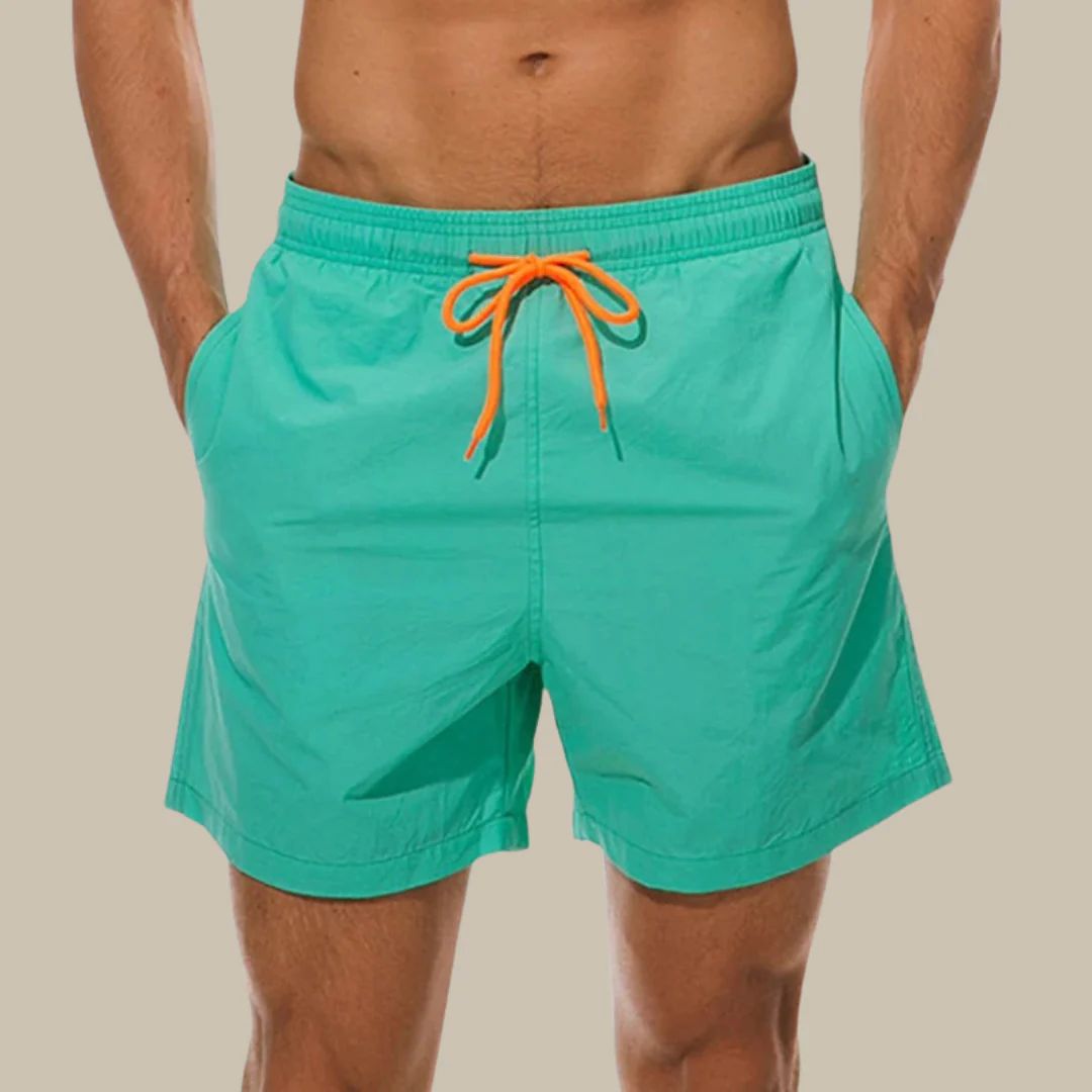Grüne Herren-Badeshorts mit orangefarbenem Kordelzug, ideal für Sommer und Strand.
