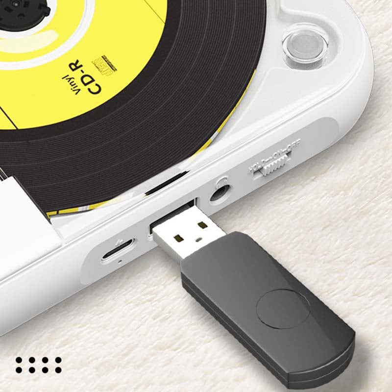 Detail boční strany přehrávače se zasunutým černým USB flash diskem, vedle jsou konektor sluchátek a posuvný přepínač. 9