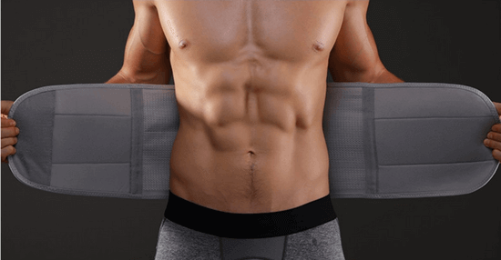 Mann mit grauem Taillentrainer, Fitnessgürtel, Bauchmuskeltraining, Sportbekleidung.