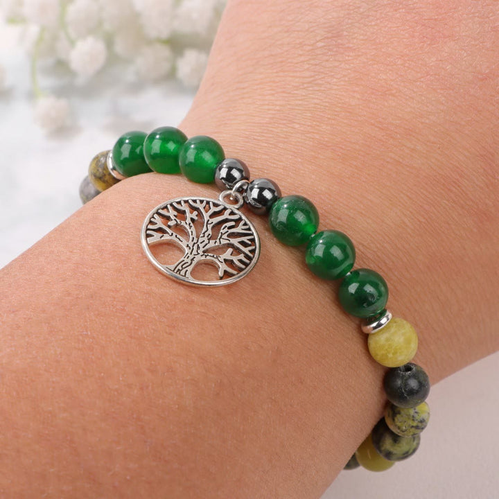 Armband mit grünen Edelsteinen und Lebensbaum-Anhänger, Schmuck, Handgelenk, modisch, elegant.