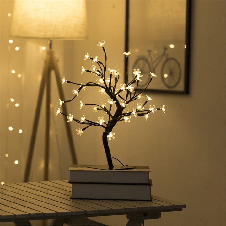 LED-Baumlampe mit warmweißen Lichtern auf Tisch, dekorative Beleuchtung, Innenraum.