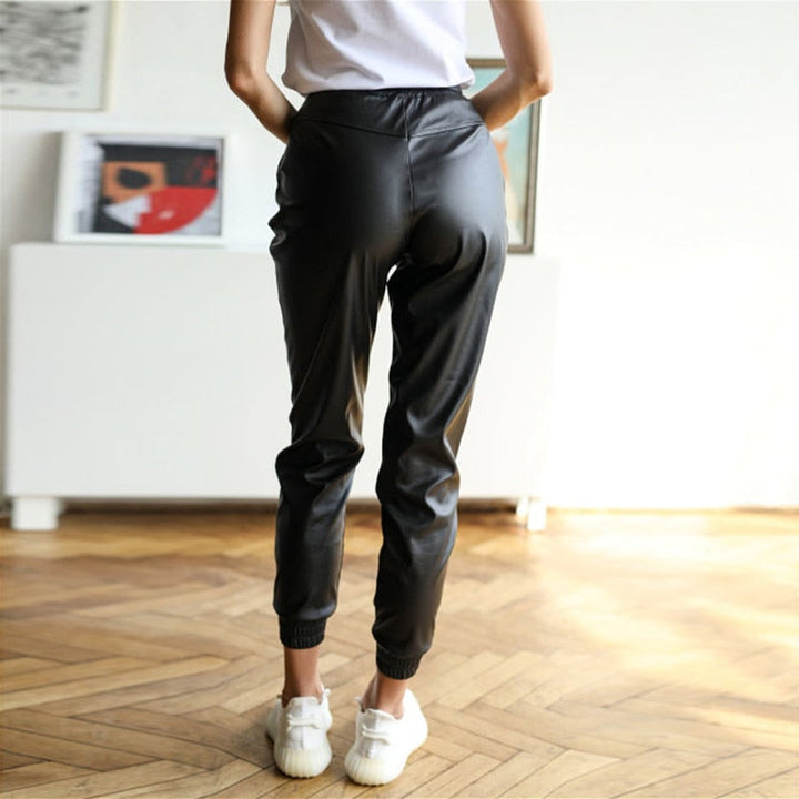 Frau in schwarzer Lederhose, Jogger-Stil, modisch, bequem, Freizeitkleidung, Innenraum.