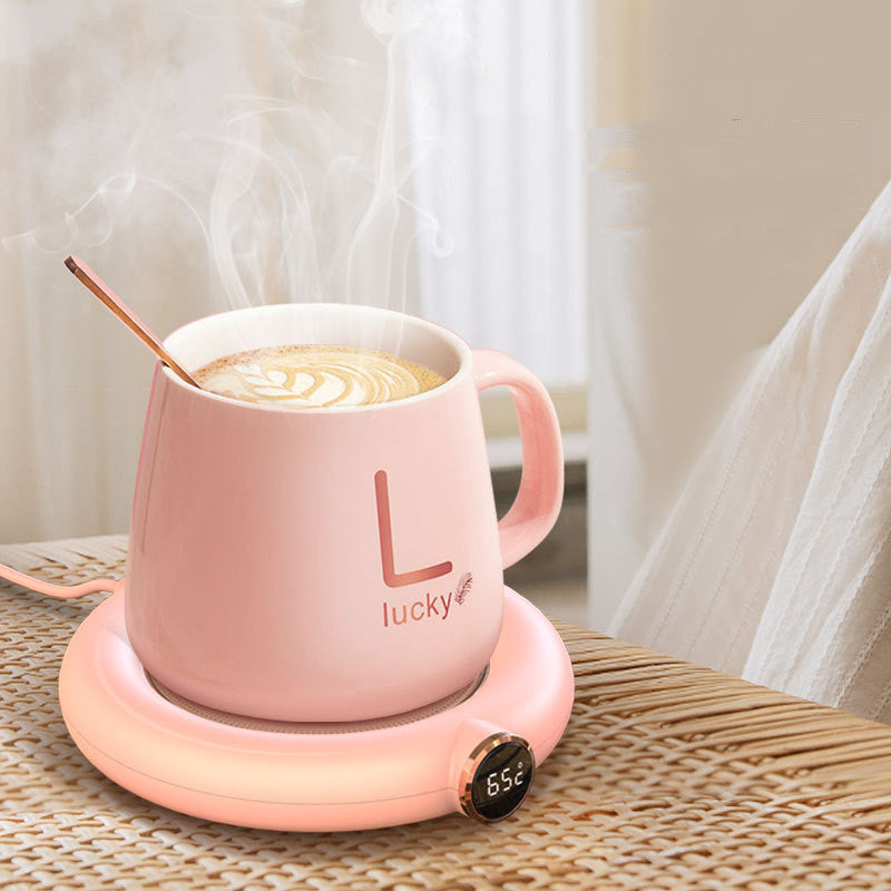Rosa Kaffeetasse mit Löffel auf Heizplatte, Latte Art, Temperaturanzeige, Keramik, 65°C.