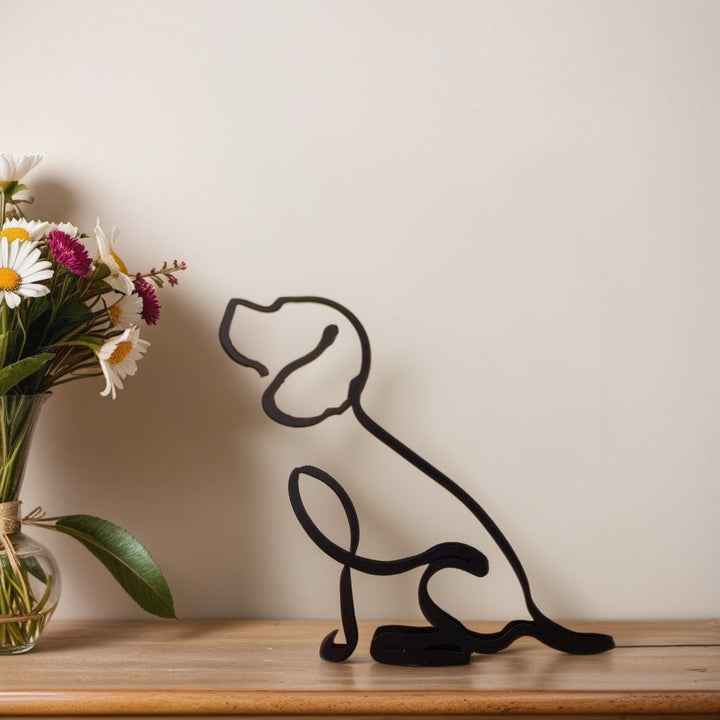 Schwarze Beagle-Skulptur aus Metall auf Holzregal neben Vase mit Blumen.