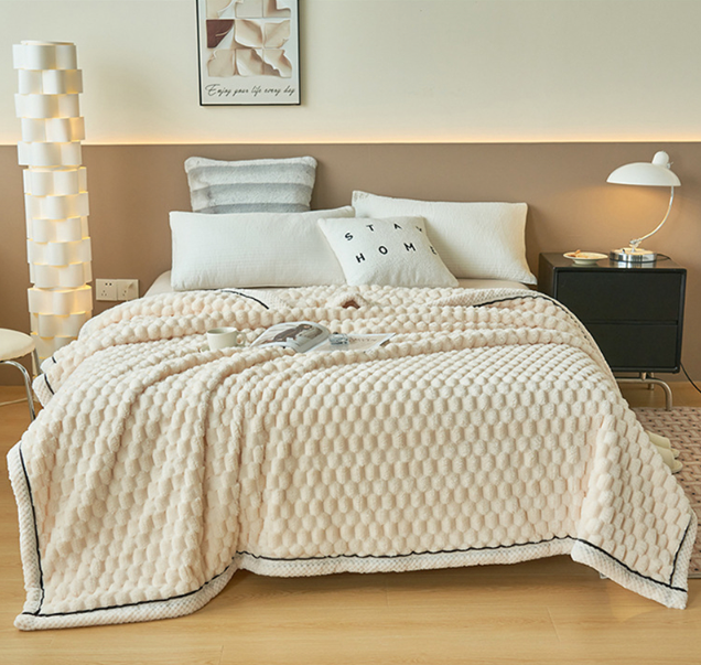 Beige Bettdecke aus Baumwolle auf modernem Bett mit Kissen, Nachttisch und Lampe im Schlafzimmer.