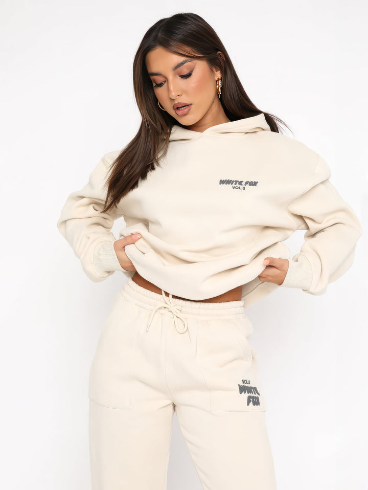 Frau in cremefarbenem Hoodie und Jogginghose, lässige Mode, Streetwear, gemütlicher Look.