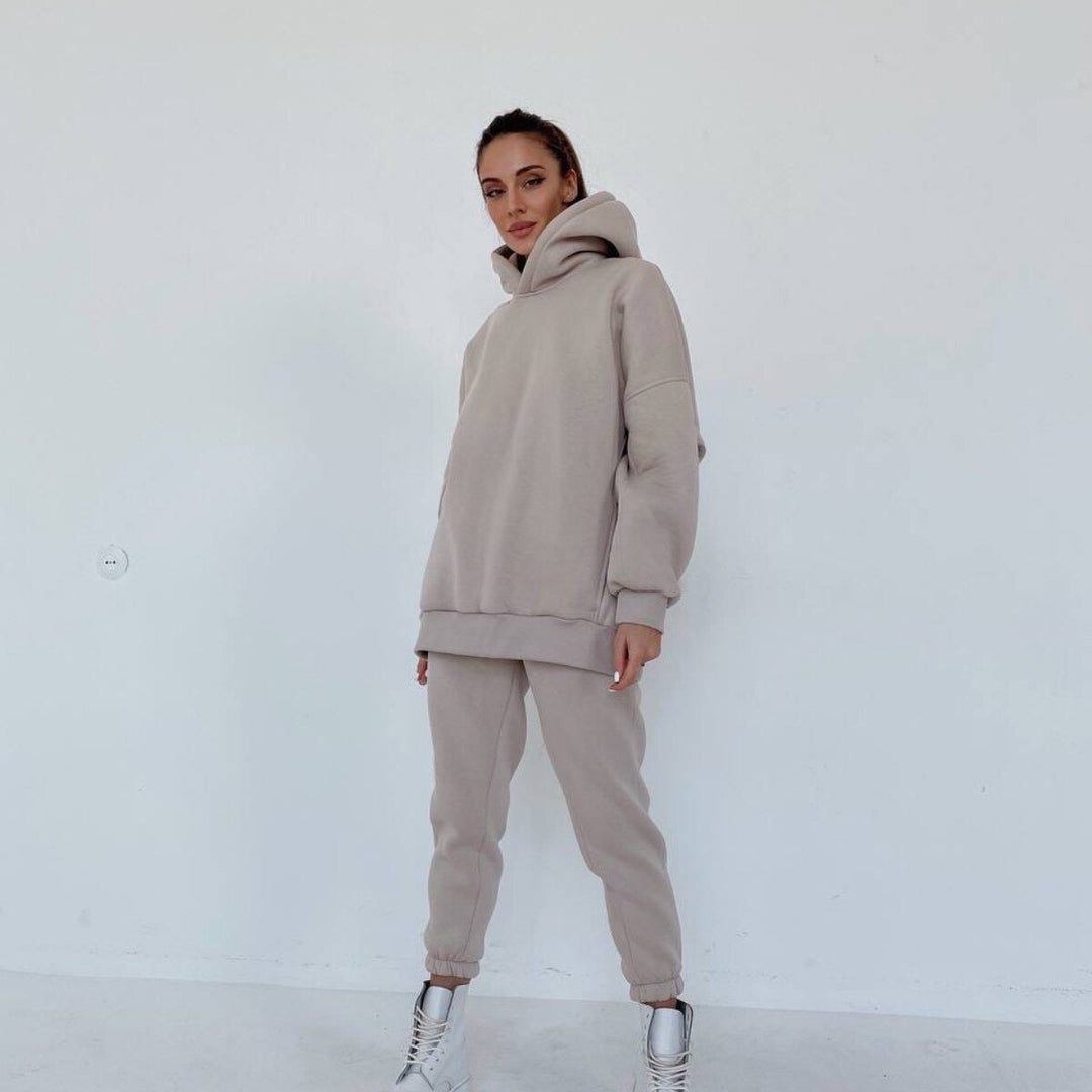 Frau in beigem Hoodie und Jogginghose, lässige Mode, gemütlicher Freizeitlook, weiße Sneaker.