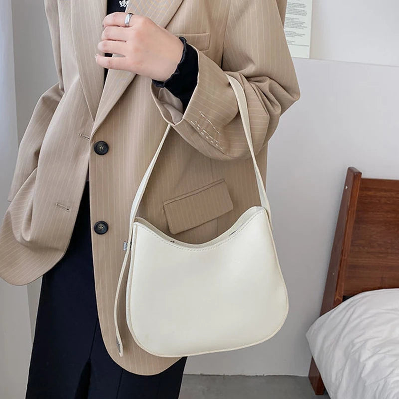 Frau mit beiger Handtasche aus Leder, elegantes Design, modisches Accessoire, beige Blazer.