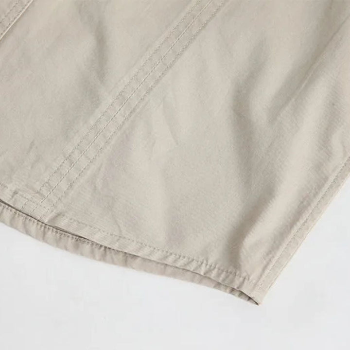 Beigefarbene Baumwolljacke, Nahaufnahme, hochwertige Nähte, modisches Design.