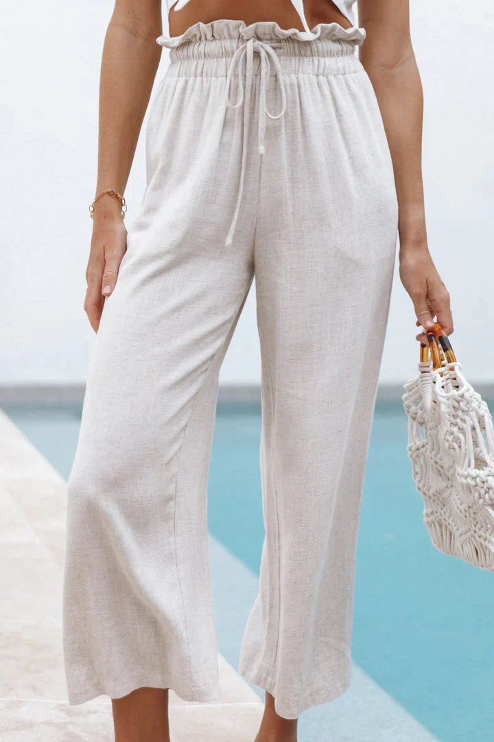 Beige Leinenhose Damen, weites Bein, hoher Bund, Sommermode, lässig, Pool-Hintergrund