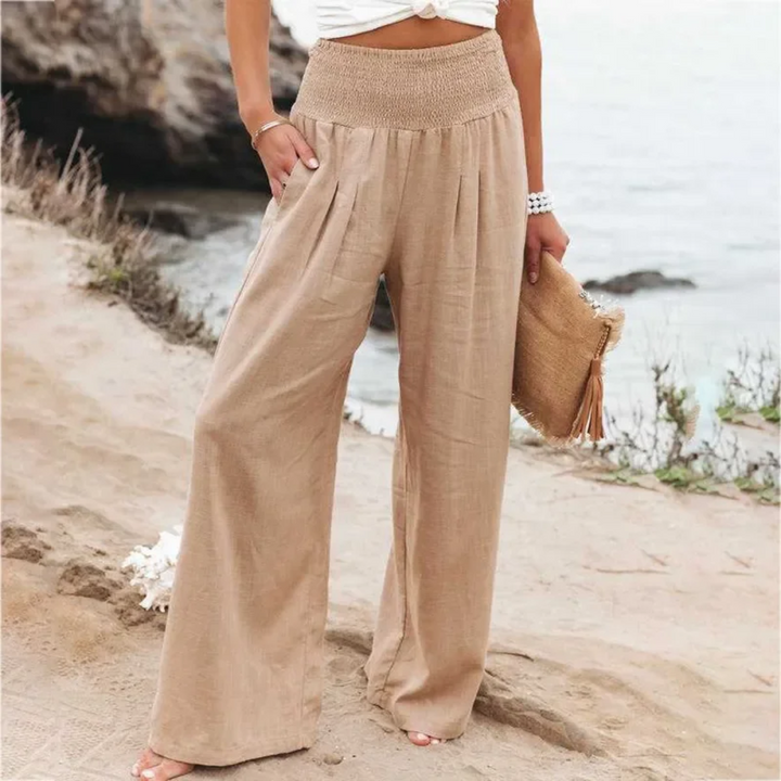 Frau in beigen Leinenhosen am Strand, Sommermode, lässiger Stil, Damenbekleidung.