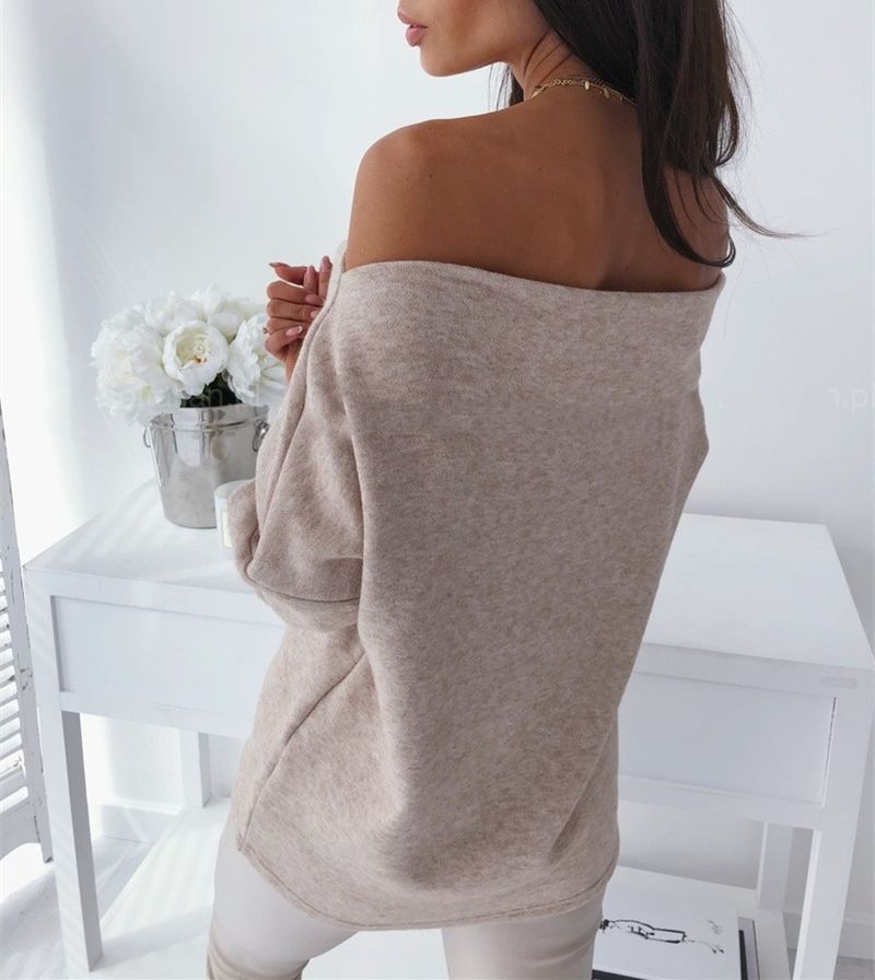 Frau in beigem Off-Shoulder-Pullover, elegantes Design, gemütliche Mode, Innenraum.