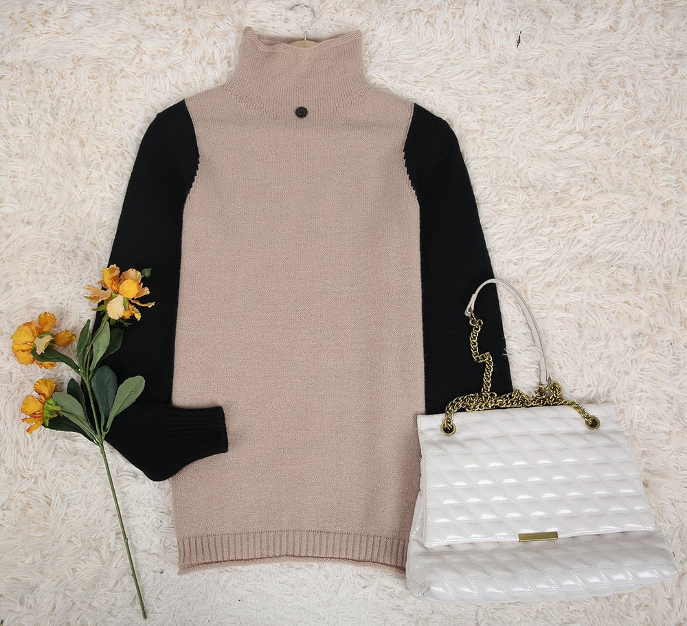 Beige Rollkragenpullover mit schwarzen Ärmeln, weiße Handtasche, gelbe Blumen auf Teppich.