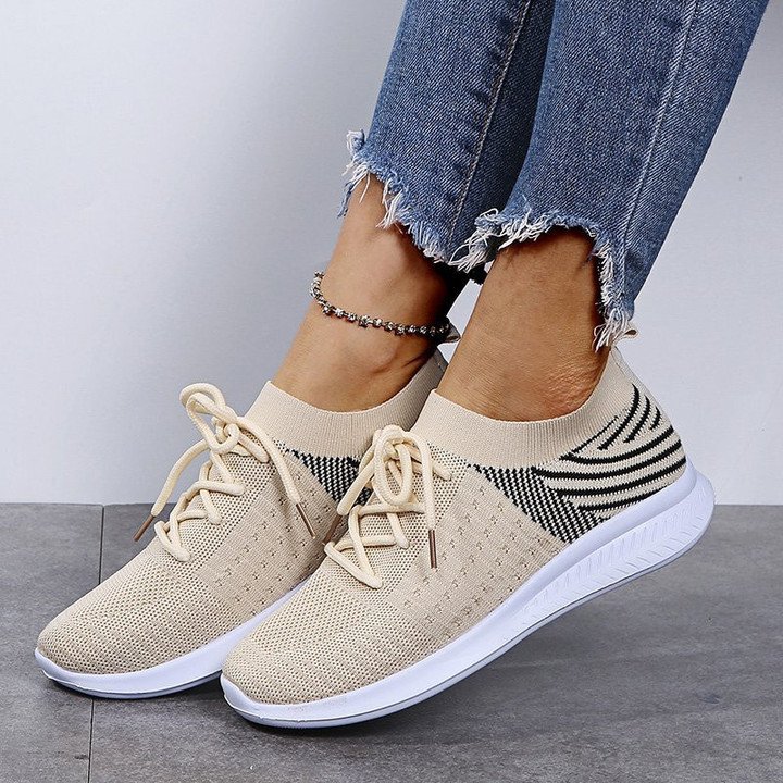 Beige Damen-Sneaker aus Strickstoff, sportlich, bequem, mit weißer Sohle und Schnürsenkeln.