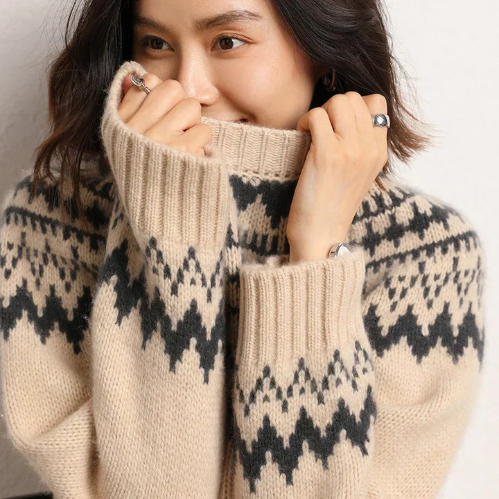 Frau in beigem Strickpullover mit Norwegermuster, lächelnd, gemütliche Wintermode.