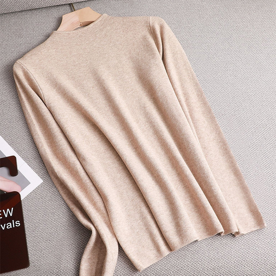 Beiger Damenpullover aus Kaschmir, langärmelig, elegant, weich, auf grauem Hintergrund.