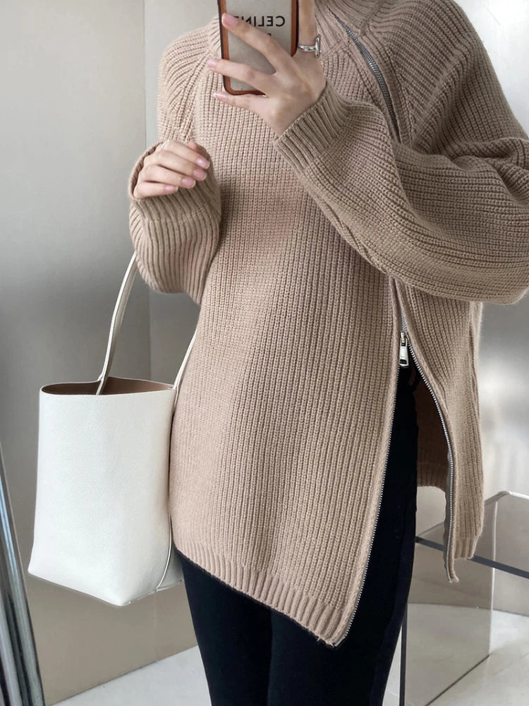 Frau in beigem Strickpullover mit weißer Ledertasche, modisch, elegant, Herbstmode.