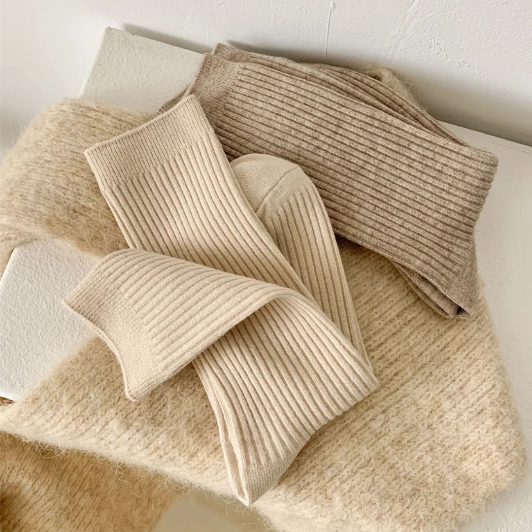Beige und braune Stricksocken aus Wolle auf Wollpullover, gemütliche Wintermode.