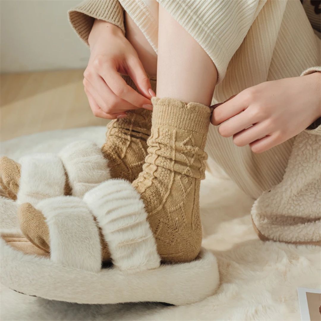 Damen in beigen Socken und flauschigen Hausschuhen auf Teppich, gemütliche Wintermode.