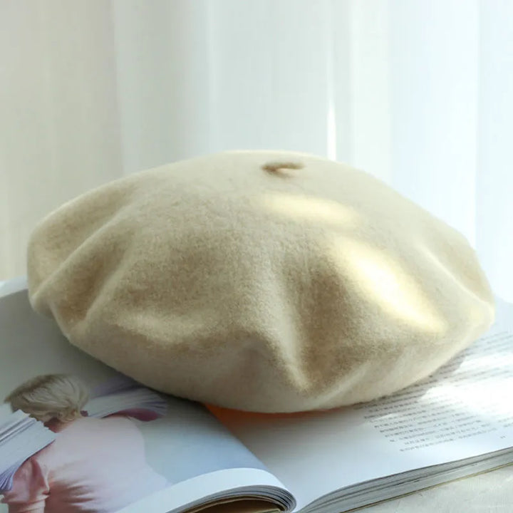 Beige Baskenmütze aus Wolle auf offenem Buch, stilvolles Accessoire, französische Mode.