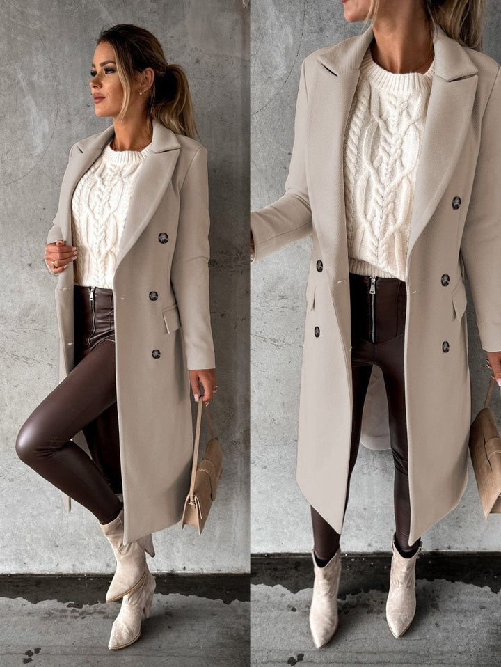 Frau in beigem Mantel, weißem Strickpullover, brauner Lederhose, Stiefeletten, Handtasche.