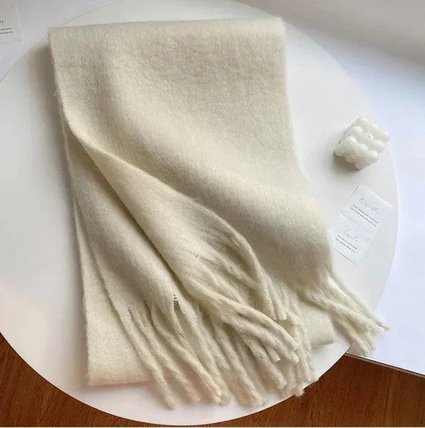 Beige Wollschal mit Fransen, weiches Material, ideal für Herbstmode, gemütliches Accessoire.