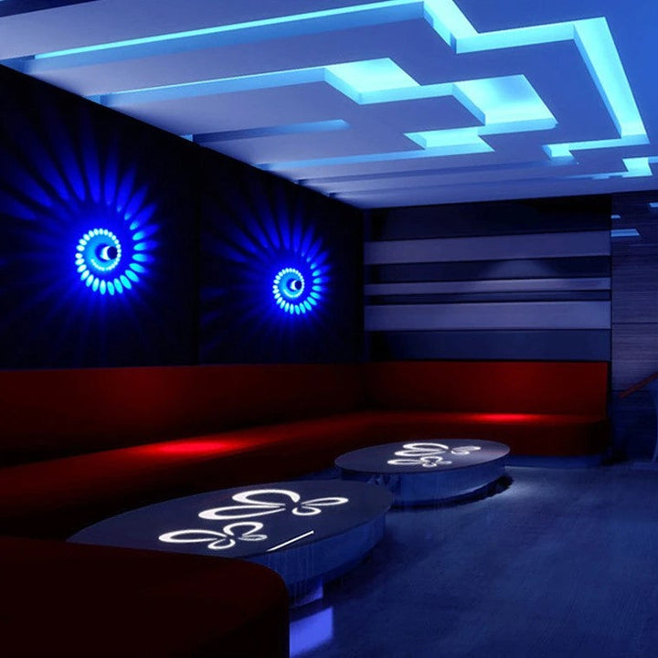 Moderne Lounge mit blauer LED-Beleuchtung, roten Sofas und stilvollen Tischen.
