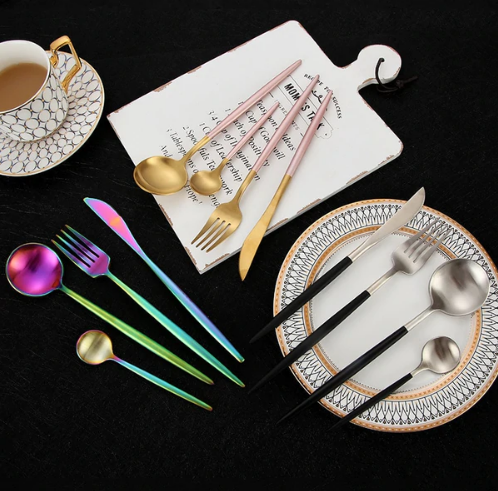 Buntes Besteck-Set aus Edelstahl, modern, mit Löffel, Gabel, Messer, auf schwarzem Hintergrund.