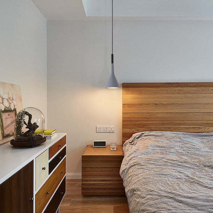 Modernes Schlafzimmer mit Holzkommode, Bett und hängender Lampe, minimalistisches Design.