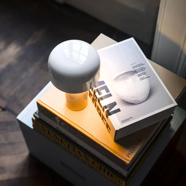 Weiße Tischlampe auf Bücherstapel, modernes Design, Wohnzimmerdekoration, Holzfußboden.