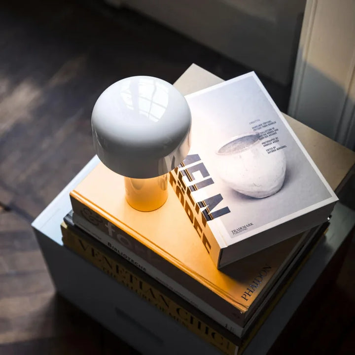 Weiße Tischlampe auf Bücherstapel, modernes Design, Wohnzimmerdekoration, Holzfußboden.