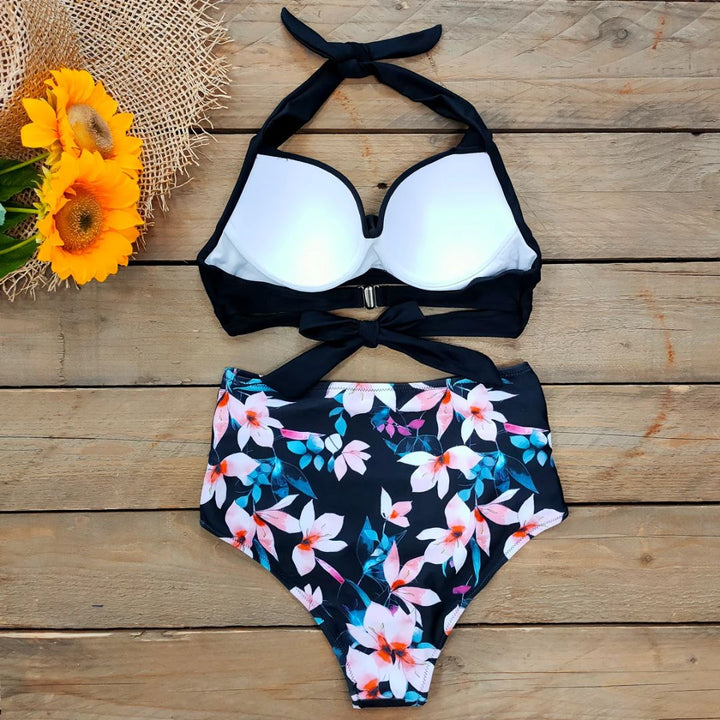 Schwarz-weißer Bikini mit Blumenmuster, hoher Taille, auf Holzhintergrund, Sonnenblumen-Deko.