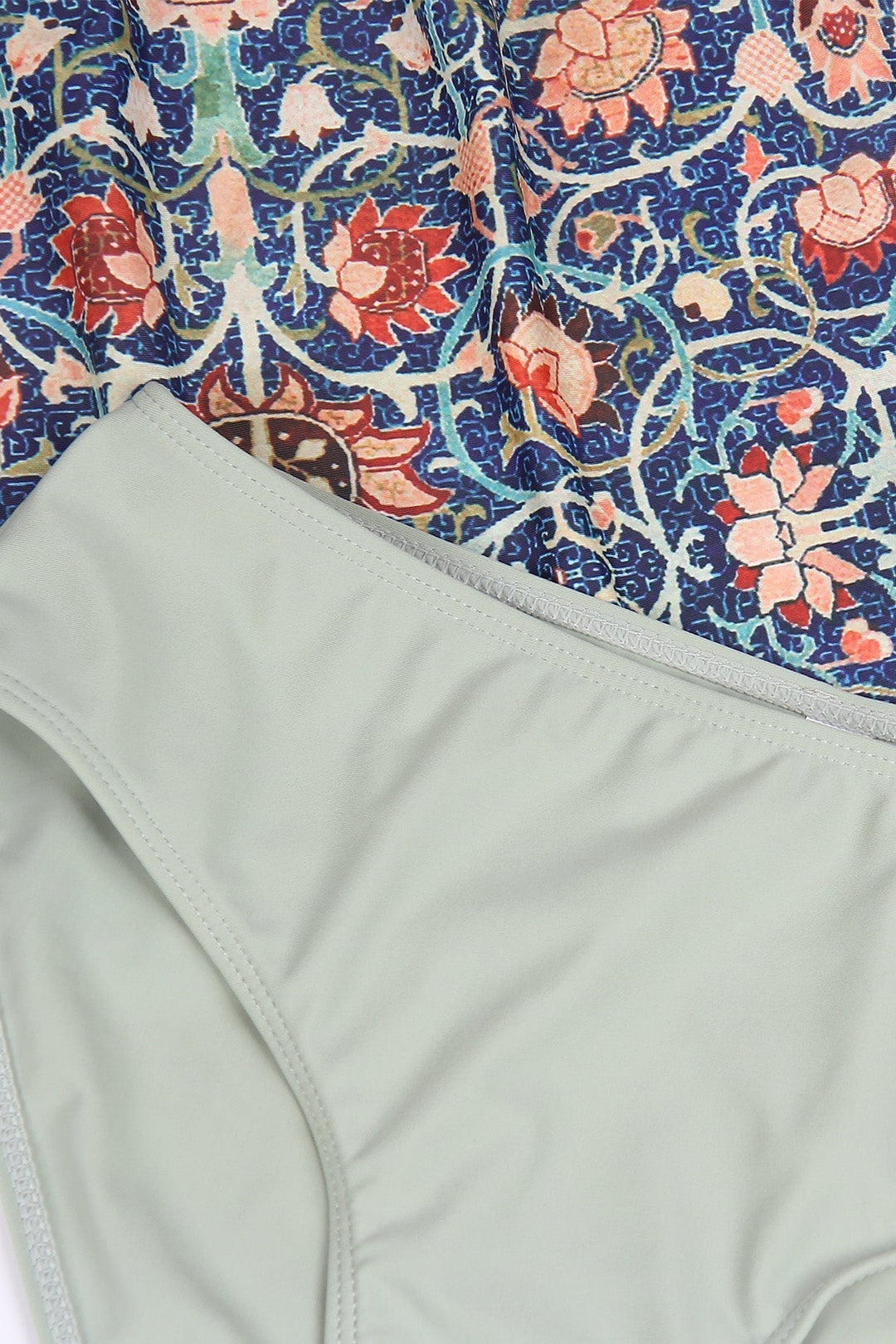 Bunte gemusterte Stoffe mit floralen Motiven und einfarbiger, hellgrüner Badeanzugstoff.