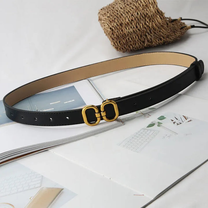 Schwarzer Ledergürtel mit goldener Schnalle auf offenem Buch, modisches Accessoire.