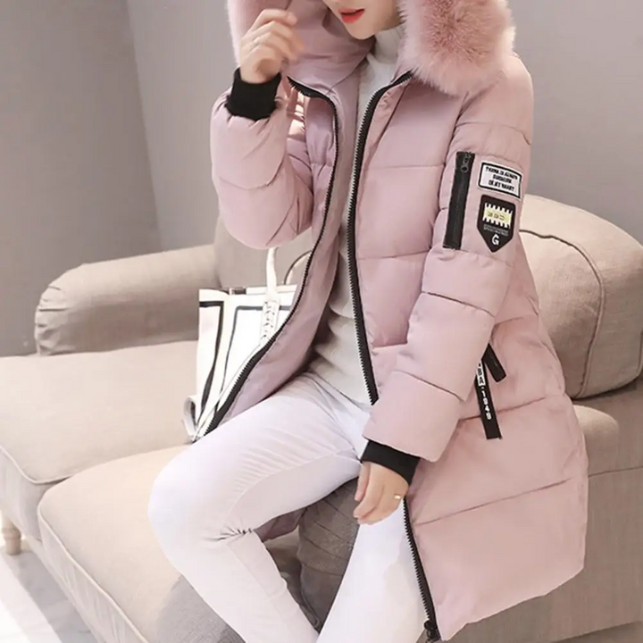Frau in rosa Daunenjacke mit Kapuze, sitzt auf Sofa, Wintermode, stilvoll, warm.
