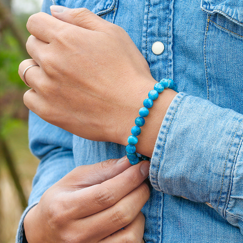 Armband aus blauem Apatit, 6mm Perlen, unisex, Meditation, Naturstein, Denim-Hintergrund.