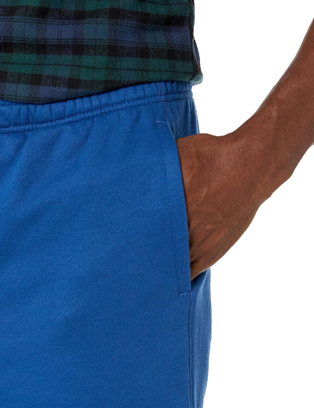 Mann in blauer Jogginghose mit Hand in der Tasche, kariertes Hemd, Freizeitmode.