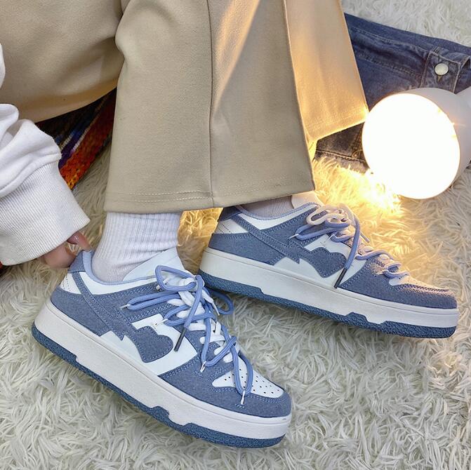 Blaue Sneaker mit weißem Logo, Low-Top, auf Teppich, modisch, lässig, Unisex-Sportschuhe.