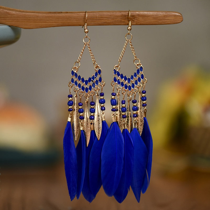 Blaue Federohrringe mit goldenen Akzenten, Boho-Stil, handgefertigt, modisches Accessoire.