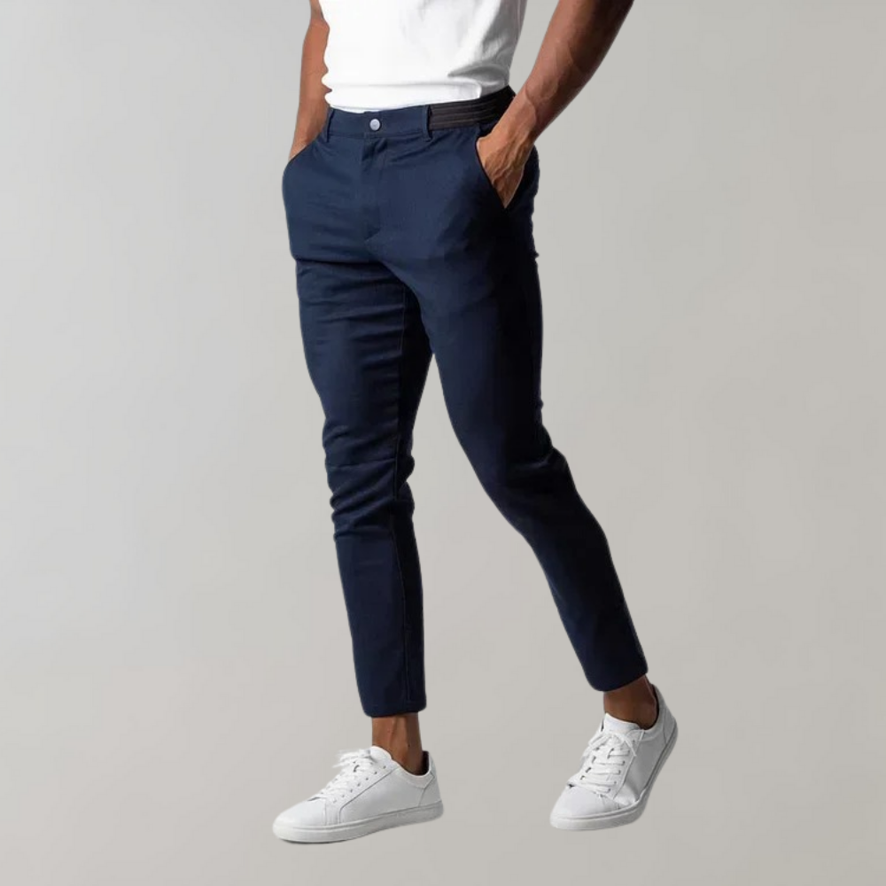 Mann trägt dunkelblaue Chinohose, weiße Sneaker, lässiger Stil, Herrenmode.