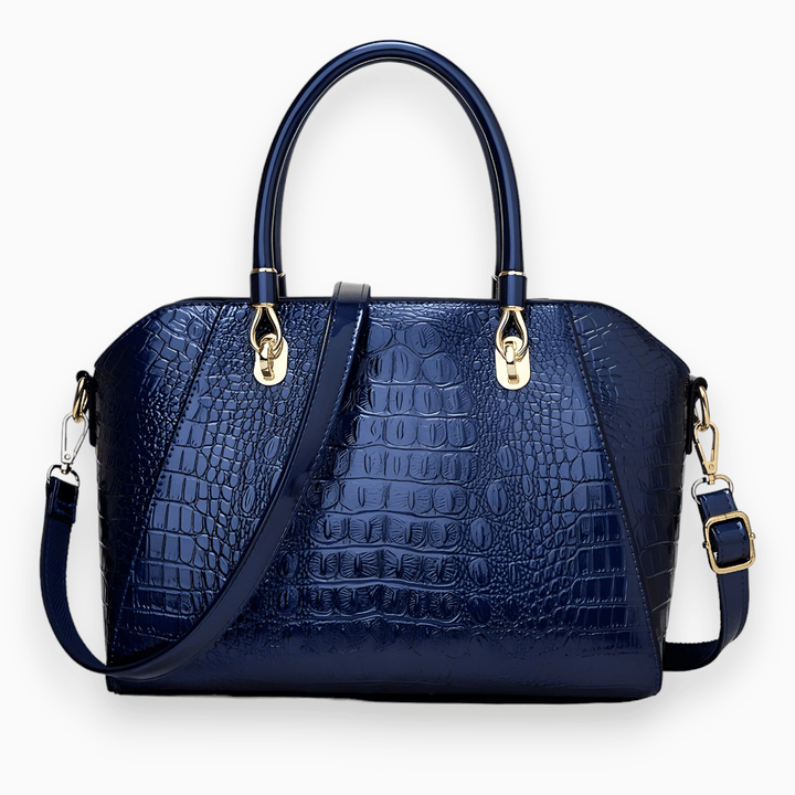 Dunkelblaue Krokodilleder-Handtasche mit goldenen Beschlägen und abnehmbarem Schulterriemen.