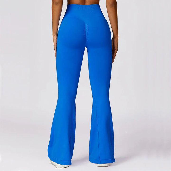 Frau in blauer Schlaghose, nahtlos, elastisch, Rückansicht, Fitnessmode, Damenbekleidung.