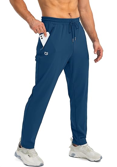 Mann in blauer Jogginghose mit Smartphone in der Tasche, Sportbekleidung, Fitnessmode.