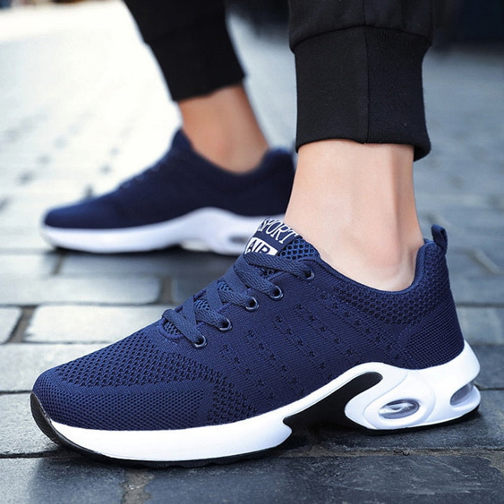 Dunkelblaue Sportschuhe, atmungsaktiv, mit weißer Sohle, ideal für Laufen und Fitness.