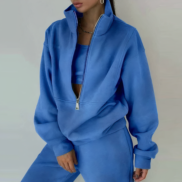 Frau in blauem Trainingsanzug mit Reißverschluss, Sportmode, Freizeitkleidung, bequemer Stil.