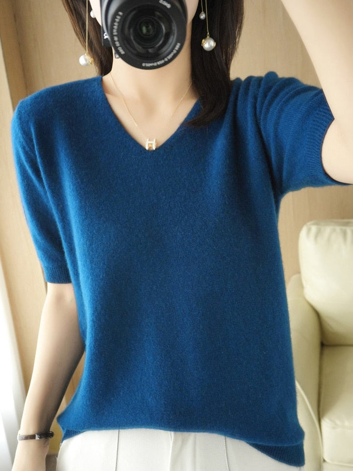 Frau in blauem V-Ausschnitt Pullover, weiches Material, modisch, Innenaufnahme.
