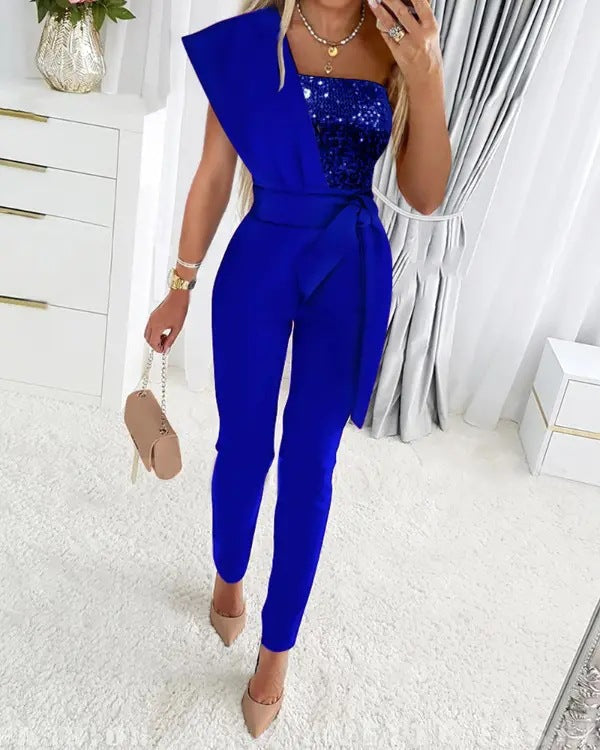 Frau in blauem Jumpsuit mit Pailletten, elegantes Design, modische Abendmode.