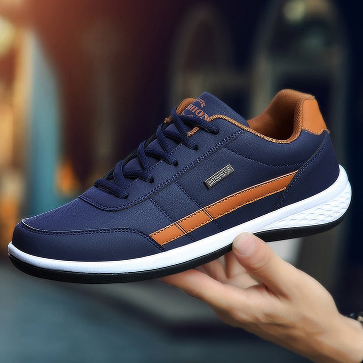 Dunkelblauer Sneaker, Herren, Leder, orange Akzente, sportlich, bequem, modisch, Freizeit.