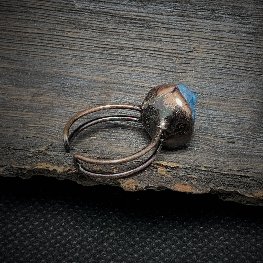 Antiker Kupferring mit blauem Edelstein auf rustikalem Holz, handgefertigter Schmuck.